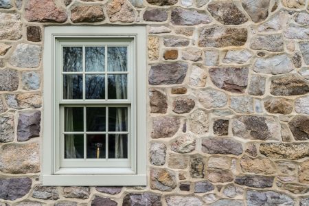 Stone home in  historic colonial window with a candle inside